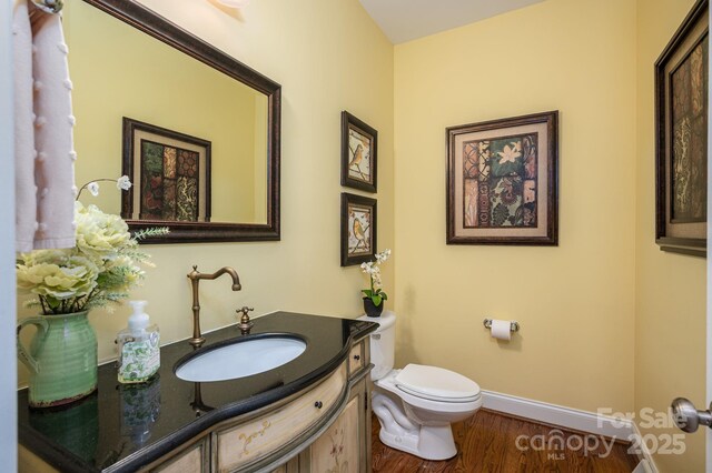 506 Academy St, Mcadenville, NC 28101 - half bath featuring toilet, baseboards, vanity, and wood finished floors