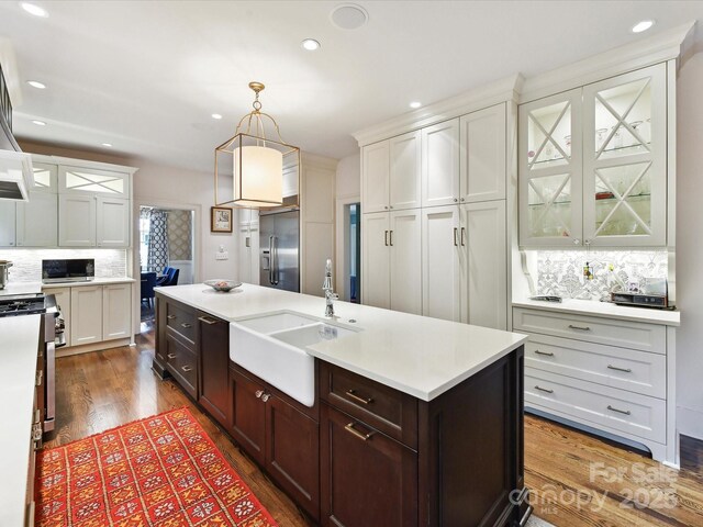 2526 Sherwood Ave, Charlotte, NC 28207 - kitchen with a sink, appliances with stainless steel finishes, backsplash, light countertops, and wood finished floors