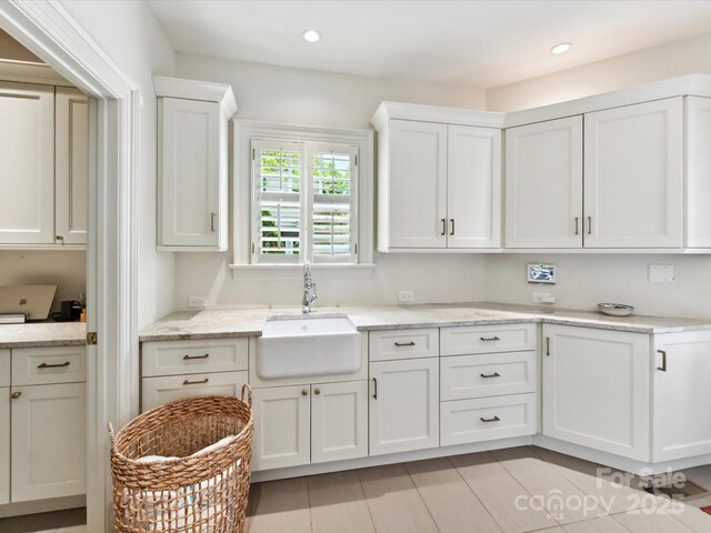 2526 Sherwood Ave, Charlotte, NC 28207 - kitchen with a sink, white cabinetry, recessed lighting, and light stone counters