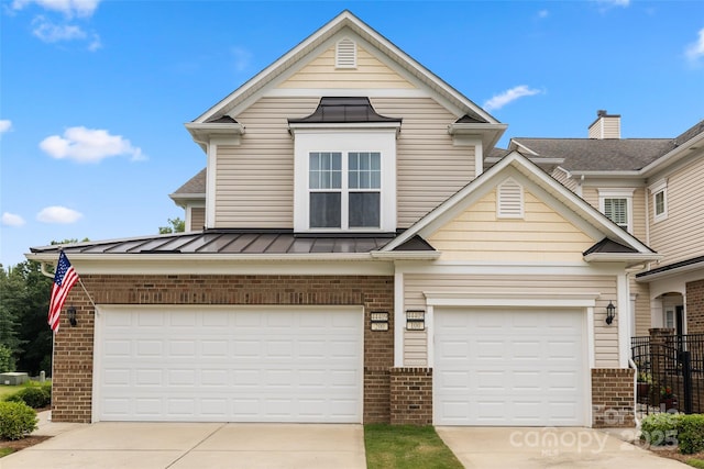 44409 Oriole Dr Unit 200, Indian Land, SC 29707 - view of front facade with brick siding, driveway, a standing seam roof, metal roof, and an attached garage