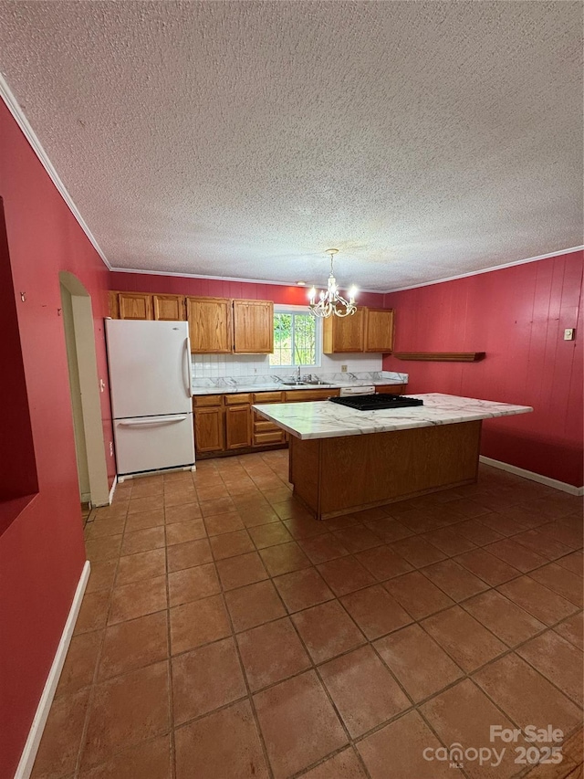 232 Cole Hollow Rd, Newland, NC 28657 - kitchen featuring freestanding refrigerator, brown cabinets, light countertops, a chandelier, and a center island