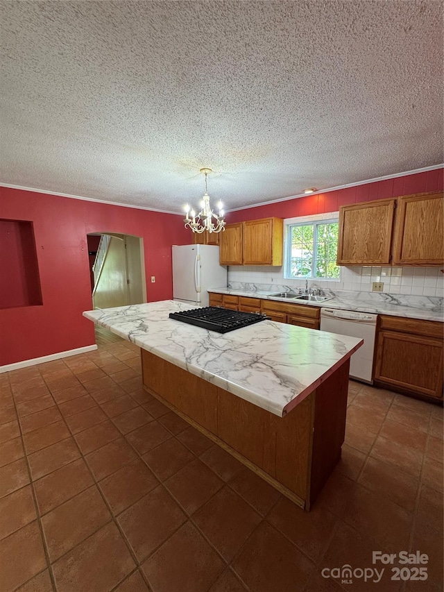 232 Cole Hollow Rd, Newland, NC 28657 - kitchen featuring white appliances, light countertops, a kitchen island, a textured ceiling, and brown cabinets