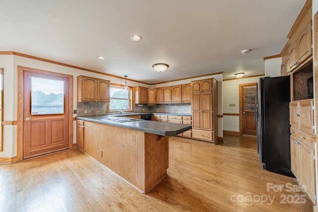 12705 Caldwell Rd, Charlotte, NC 28213 - kitchen featuring black appliances, a peninsula, light wood-style flooring, crown molding, and backsplash