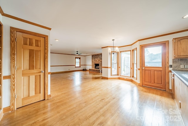 12705 Caldwell Rd, Charlotte, NC 28213 - unfurnished living room with light wood-style flooring, ornamental molding, and a brick fireplace