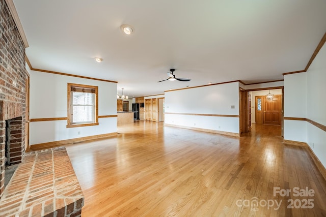 12705 Caldwell Rd, Charlotte, NC 28213 - unfurnished living room with a brick fireplace, ornamental molding, a ceiling fan, light wood-style flooring, and a chandelier