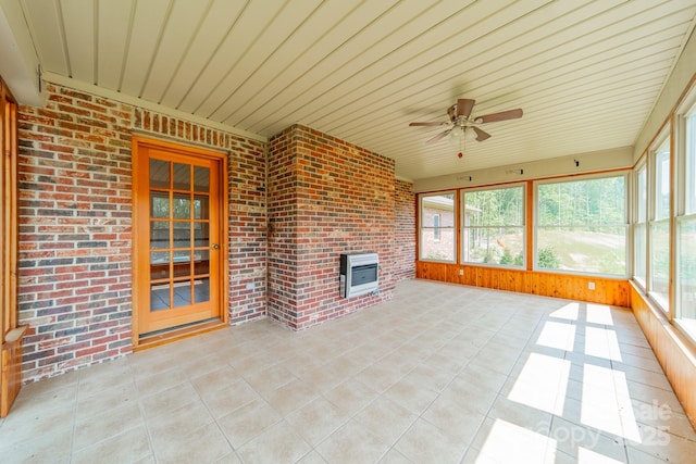 12705 Caldwell Rd, Charlotte, NC 28213 - unfurnished sunroom featuring heating unit, ceiling fan, tile patterned flooring, brick wall, and wood walls