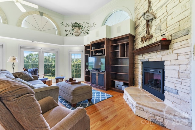 3541 Blankenship Dr, Morganton, NC 28655 - living area with a stone fireplace, healthy amount of natural light, a high ceiling, light wood finished floors, and a ceiling fan