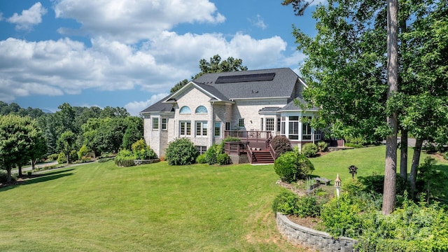 3541 Blankenship Dr, Morganton, NC 28655 - back of house with a lawn, a wooden deck, brick siding, a sunroom, and a shingled roof