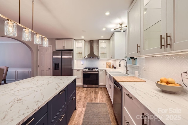 7810 Leisure Ln, Huntersville, NC 28078 - kitchen with appliances with stainless steel finishes, wall chimney range hood, light wood-style flooring, white cabinets, and recessed lighting