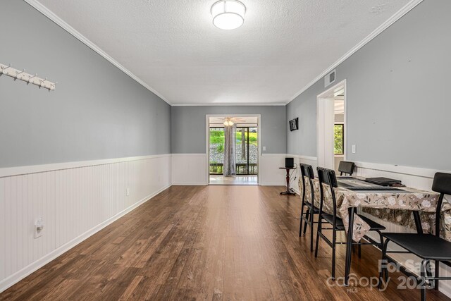 15 Lake Dr Unit D2, Laurel Park, NC 28739 - dining room featuring wood finished floors, crown molding, a wainscoted wall, and a textured ceiling