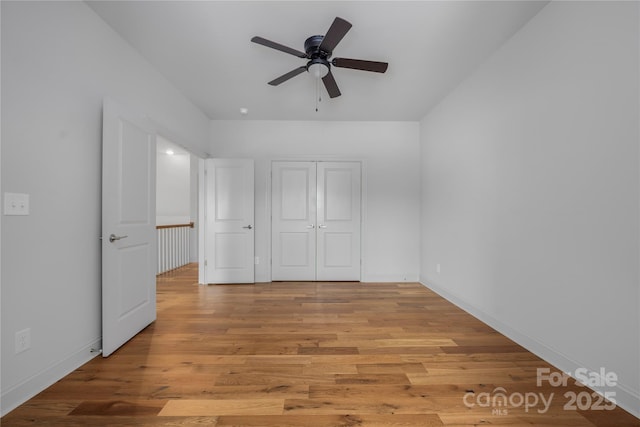3008 Laney Pond Rd, Matthews, NC 28104 - unfurnished bedroom featuring light wood-style flooring, baseboards, a closet, and a ceiling fan
