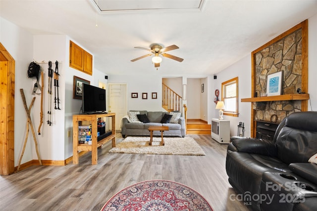 242 Ladd Parsons Rd, Crumpler, NC 28617 - living room featuring attic access, light wood-style flooring, a ceiling fan, baseboards, and a stone fireplace