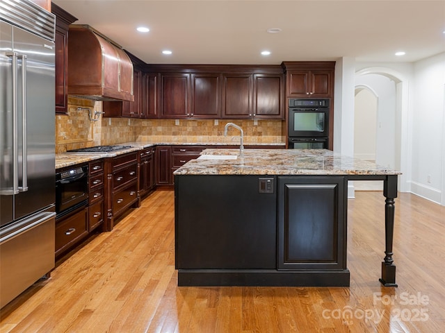 50 Brookline Dr, Asheville, NC 28803 - kitchen featuring stainless steel appliances, ventilation hood, light wood finished floors, a sink, and light stone countertops