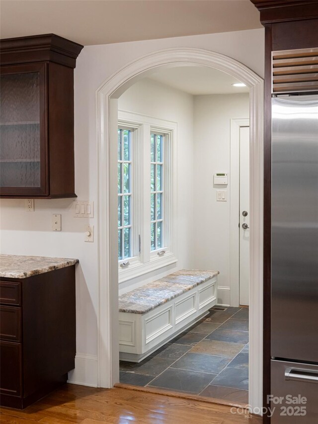 50 Brookline Dr, Asheville, NC 28803 - kitchen featuring high end refrigerator, dark brown cabinetry, arched walkways, and glass insert cabinets