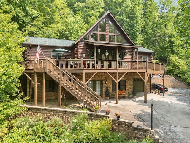 158 Raven Blvd, Lake Lure, NC 28746 - back of property featuring log exterior, driveway, a wooden deck, and a garage