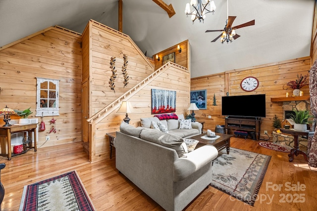 158 Raven Blvd, Lake Lure, NC 28746 - living area featuring wood walls, a ceiling fan, wood finished floors, stairs, and high vaulted ceiling