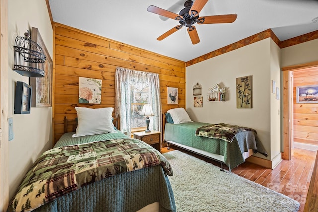 158 Raven Blvd, Lake Lure, NC 28746 - bedroom with wood walls, wood finished floors, a ceiling fan, and baseboards