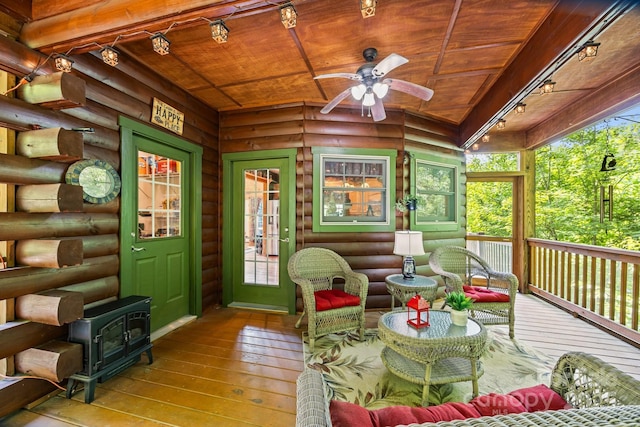 158 Raven Blvd, Lake Lure, NC 28746 - sunroom / solarium with rail lighting, a wood stove, ceiling fan, and an outdoor hangout area