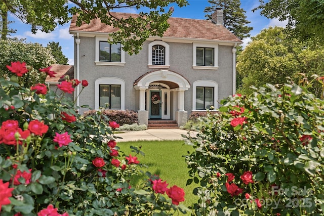 1619 Providence Rd, Charlotte, NC 28207 - view of front of property featuring a chimney, stucco siding, a front yard, and a tile roof
