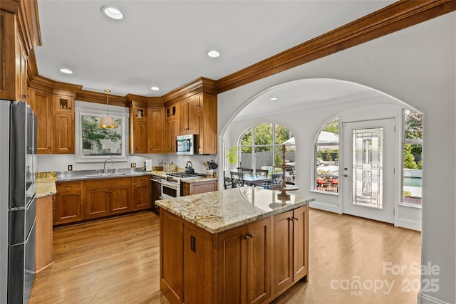 1619 Providence Rd, Charlotte, NC 28207 - kitchen featuring stainless steel appliances, brown cabinetry, light wood finished floors, a center island, and recessed lighting