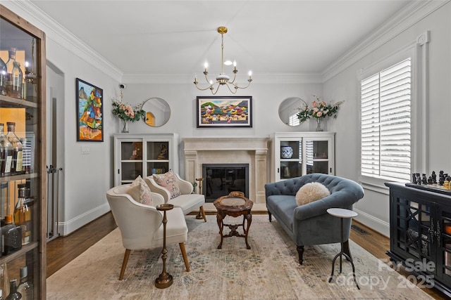 1619 Providence Rd, Charlotte, NC 28207 - living area featuring wood finished floors, ornamental molding, a chandelier, a glass covered fireplace, and baseboards
