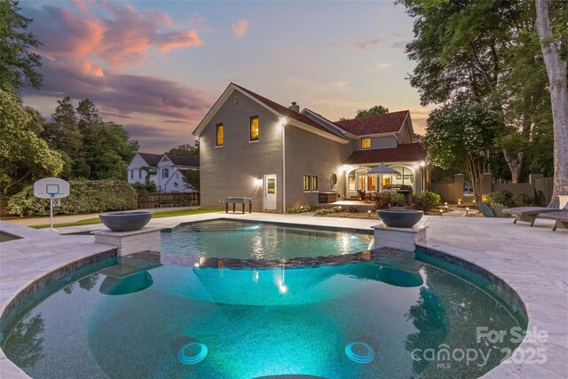 1619 Providence Rd, Charlotte, NC 28207 - pool at dusk featuring a pool with connected hot tub and a patio area