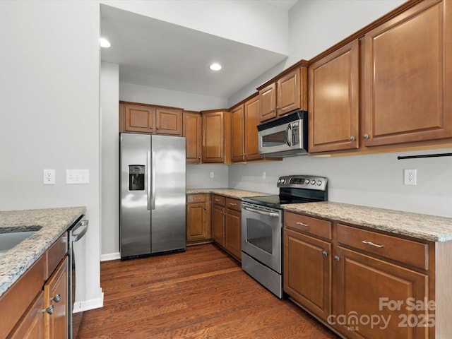 1660 Beleek Ridge Ln, Lake Wylie, SC 29710 - kitchen with appliances with stainless steel finishes, dark wood finished floors, light stone countertops, brown cabinetry, and recessed lighting