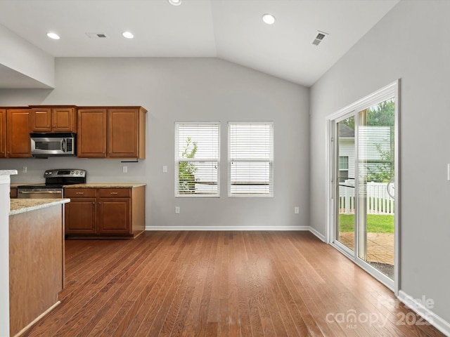 1660 Beleek Ridge Ln, Lake Wylie, SC 29710 - kitchen with appliances with stainless steel finishes, dark wood-style floors, plenty of natural light, brown cabinetry, and vaulted ceiling