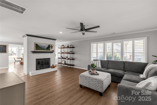 22 Honeysuckle Ln, Clover, SC 29710 - living area with baseboards, wood finished floors, ceiling fan, a brick fireplace, and ornamental molding
