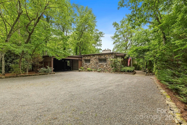 21 Rhododendron Rd, Black Mountain, NC 28711 - view of front of house featuring gravel driveway, stone siding, and a chimney