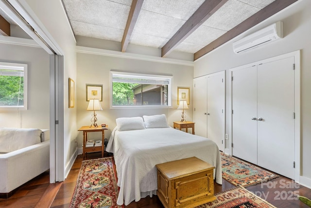 21 Rhododendron Rd, Black Mountain, NC 28711 - bedroom with a wall mounted air conditioner, two closets, beam ceiling, dark wood-style flooring, and baseboards