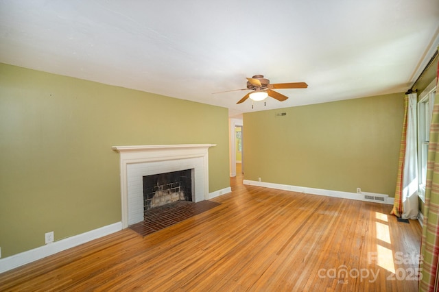 409 Edgewood Ct, Lancaster, SC 29720 - unfurnished living room with wood finished floors, a ceiling fan, a brick fireplace, and baseboards