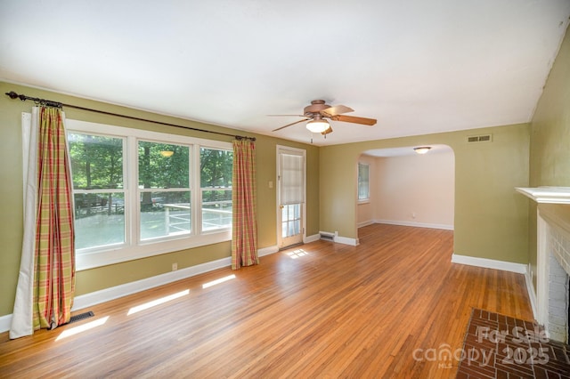 409 Edgewood Ct, Lancaster, SC 29720 - unfurnished living room with light wood finished floors, arched walkways, a ceiling fan, and baseboards