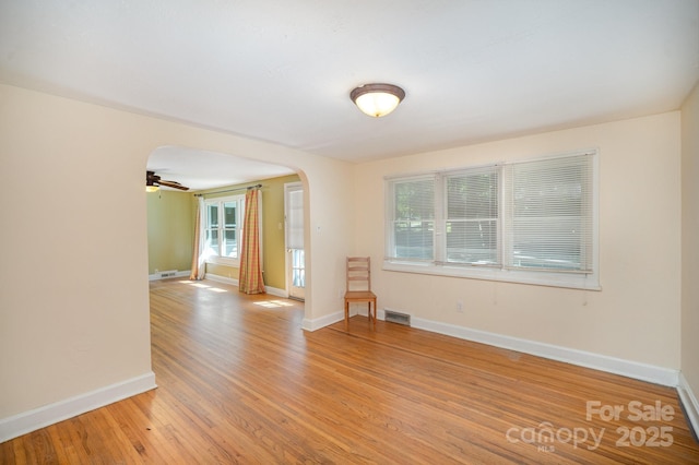 409 Edgewood Ct, Lancaster, SC 29720 - unfurnished room featuring arched walkways, plenty of natural light, light wood finished floors, and baseboards