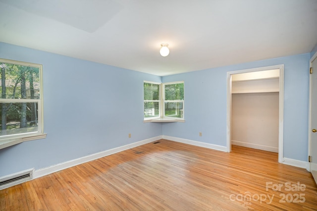 409 Edgewood Ct, Lancaster, SC 29720 - unfurnished bedroom with multiple windows, light wood-style floors, baseboards, and baseboard heating