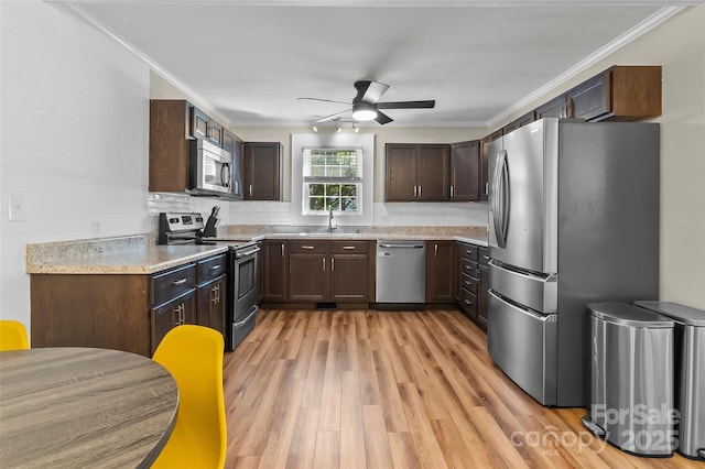 1072 5th St NE, Hickory, NC 28601 - kitchen with stainless steel appliances, a ceiling fan, light wood finished floors, dark brown cabinets, and light countertops