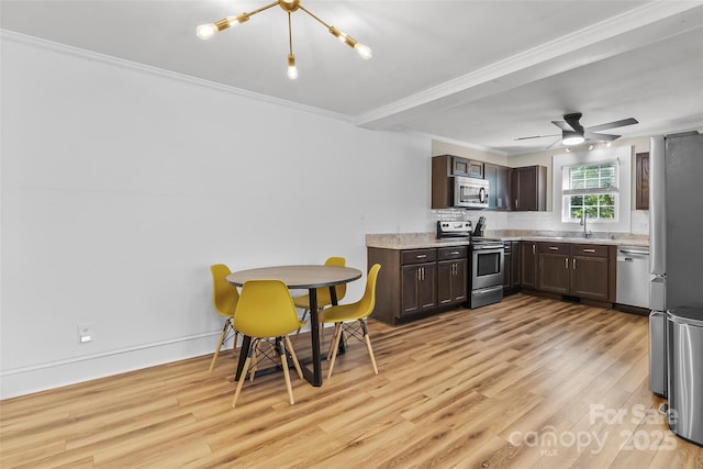 1072 5th St NE, Hickory, NC 28601 - kitchen with appliances with stainless steel finishes, dark brown cabinets, light wood finished floors, light countertops, and ornamental molding