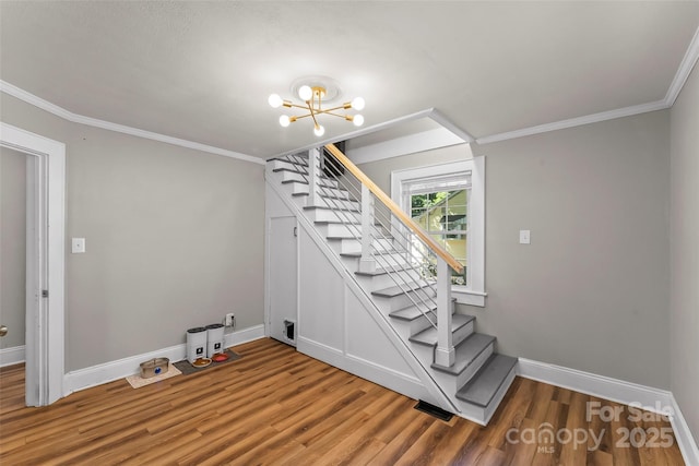 1072 5th St NE, Hickory, NC 28601 - staircase with wood finished floors, ornamental molding, and a chandelier