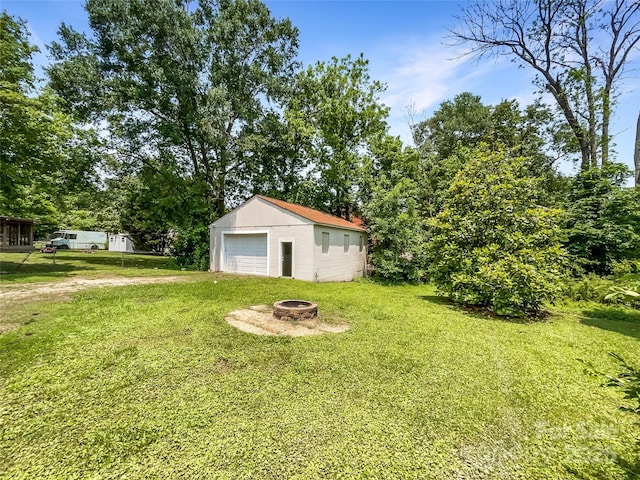 2136 W 6th Ave, Gastonia, NC 28052 - view of green lawn with a fire pit, a garage, and an outbuilding