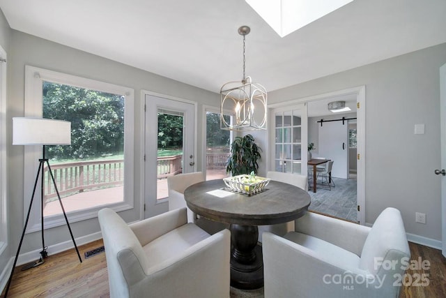 3800 Lovett Cir, Charlotte, NC 28210 - dining space with wood finished floors, a chandelier, and a skylight
