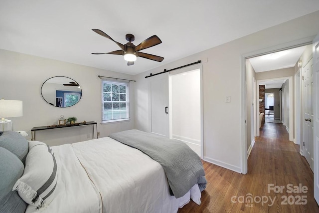 3800 Lovett Cir, Charlotte, NC 28210 - bedroom featuring wood finished floors, multiple windows, a barn door, and a ceiling fan
