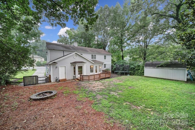 3800 Lovett Cir, Charlotte, NC 28210 - back of property featuring a trampoline, a deck, a storage unit, a fire pit, and a chimney