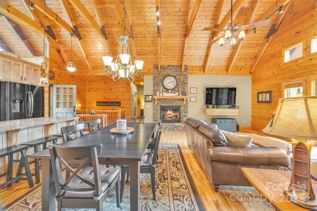 265 Laurel Mountain Estates Dr, Todd, NC 28684 - dining room with wooden walls, light wood-style flooring, wooden ceiling with exposed beams, a chandelier, and a stone fireplace