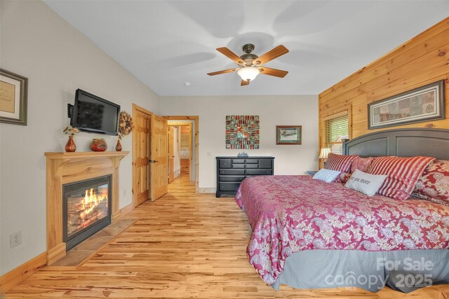 265 Laurel Mountain Estates Dr, Todd, NC 28684 - bedroom with light wood-style floors, a glass covered fireplace, baseboards, and ceiling fan