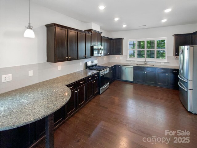1680 Trentwood Dr, Fort Mill, SC 29715 - kitchen featuring appliances with stainless steel finishes, dark wood finished floors, light stone counters, a sink, and backsplash