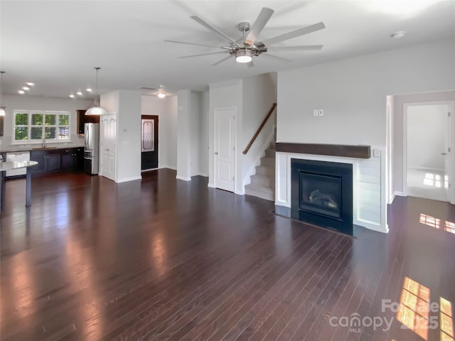 1680 Trentwood Dr, Fort Mill, SC 29715 - unfurnished living room featuring a ceiling fan, dark wood-style floors, a sink, and stairs