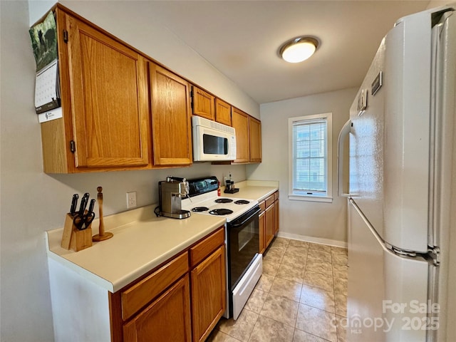 116 Grand Blvd Unit 4-B, Boone, NC 28607 - kitchen featuring white appliances, brown cabinets, light countertops, baseboards, and light tile patterned floors