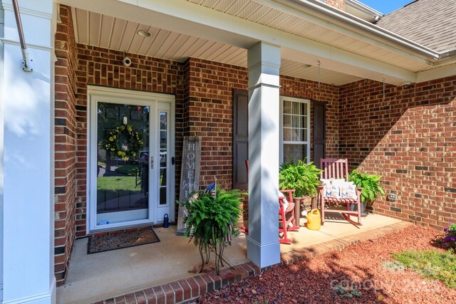 1006 Apogee Dr, Indian Trail, NC 28079 - entrance to property featuring brick siding, covered porch, and a shingled roof