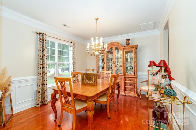 1006 Apogee Dr, Indian Trail, NC 28079 - dining room with a chandelier, crown molding, a wainscoted wall, light wood-type flooring, and a decorative wall