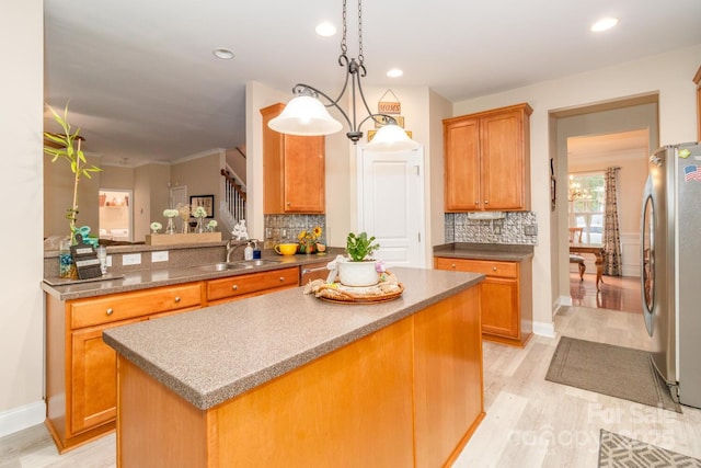 1006 Apogee Dr, Indian Trail, NC 28079 - kitchen featuring freestanding refrigerator, light wood-style flooring, decorative backsplash, a kitchen island, and recessed lighting